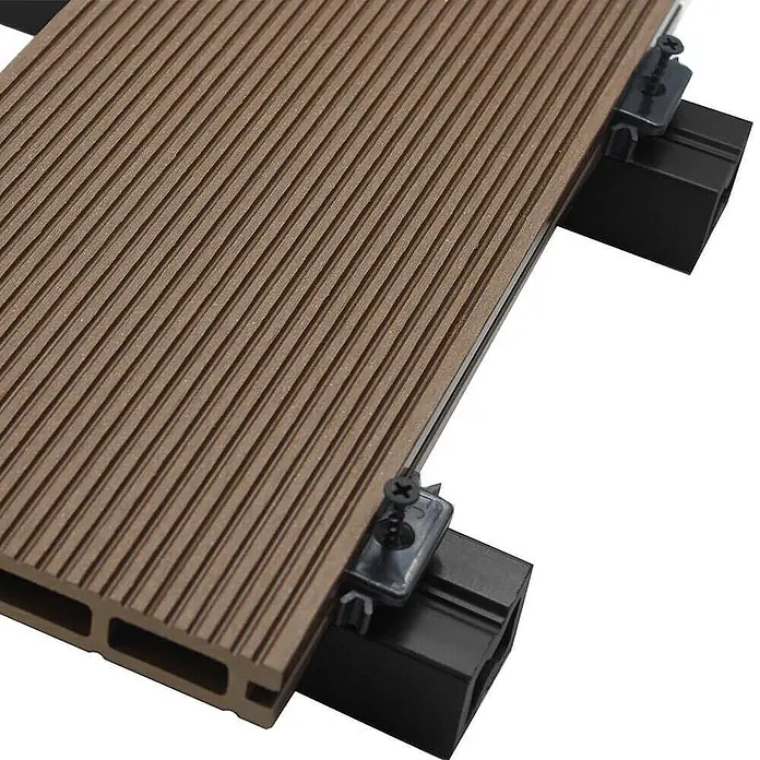 Home Deluxe Terrassenfliese SAMANA 2m² - Dunkelbraun, Matt - Nahaufnahme einer braunen Terrassendiele mit schwarzen Montageclips. Das WPC-Terrassensystem ist wetterfest und langlebig.