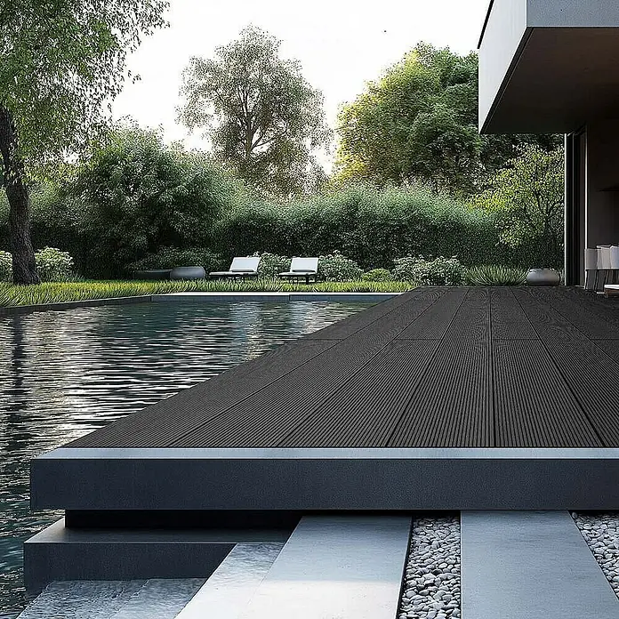 Home Deluxe Terrassenfliese SAMANA 2m² - Anthrazit, Matt - Moderne Terrasse mit dunklem Holzboden am Pool, umgeben von üppigem Grün. Perfekt für entspannte Stunden im Freien und stilvolles Ambiente.