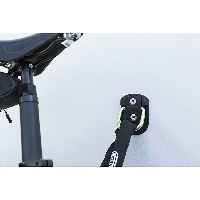 Abus Boden-Einschraubanker WBA60 - Wand- und Bodenmontage - Nahaufnahme eines ABUS Wandankers und eines Fahrradsattels, ideal zur Sicherung von Fahrrädern in Innenräumen oder Garagen.