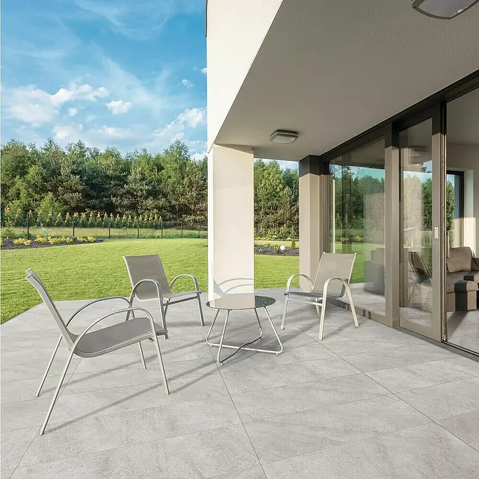Terrassenfliese Durastone - 60 x 120 x 2 cm, Grau, Matt - Terrasse mit grauen Fliesen, Stühlen und Tisch, die eine einladende Atmosphäre im Freien schaffen.