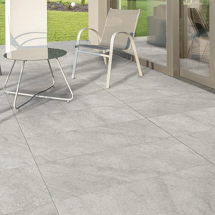 Terrassenfliese Durastone - 60 x 120 x 2 cm, Grau, Matt - Bilder von modernen grauen Terrassenfliesen. Die Fliesen sind auf einer Terrasse mit Stühlen und einem Tisch verlegt und wirken sehr elegant.
