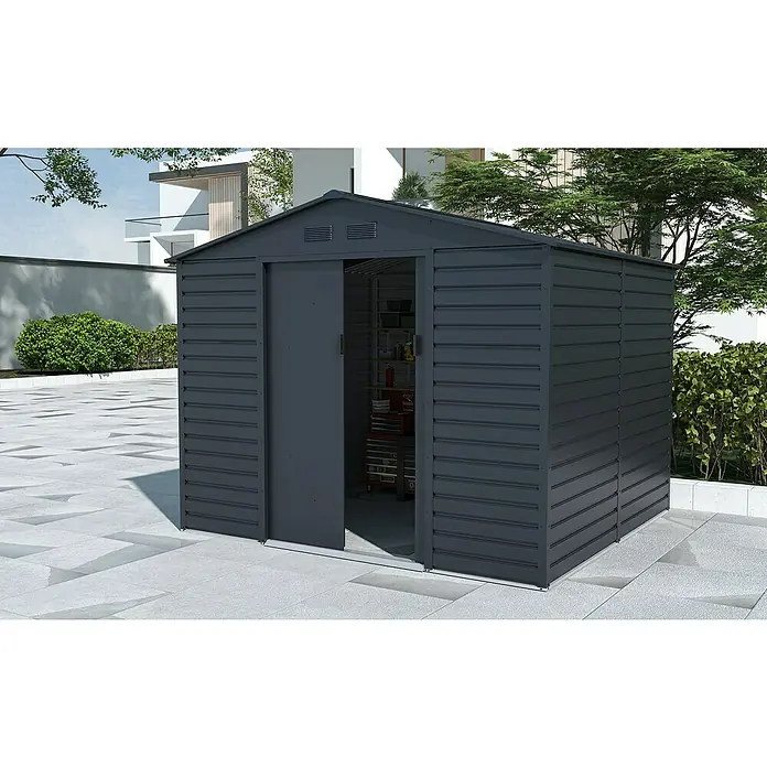 Gardol Gerätehaus Easy One Max - Außenmaß inkl. Dachüberstand (B x T): 277 x 259 cm, Stahl, Anthrazit - Ein graues Metallgartenhaus mit Schiebetür steht auf einer gepflasterten Fläche. Das Gartenhaus bietet praktischen Stauraum für den Garten.