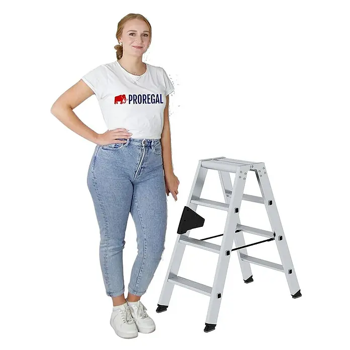 Proregal Doppel-Stehleiter beidseitig begehbar - Anzahl Tritte: 8 Stk., Arbeitshöhe: 2.450 mm, Belastbarkeit: 150 kg, Aluminium - Silberner Aluminium-Klapptritt neben einer Frau.