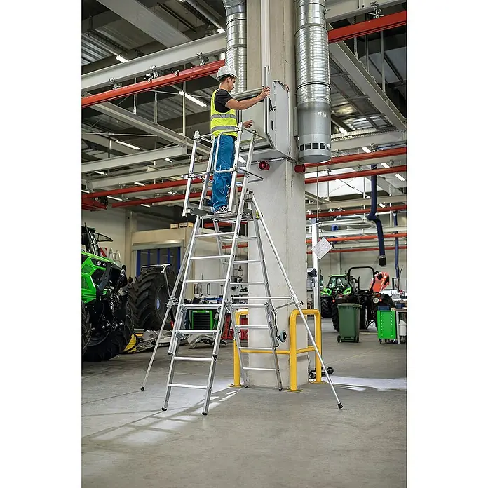 Proregal Stehleiter Plattformleiter Flexstep - Anzahl Tritte: 5 Stk., Belastbarkeit: 150 kg, Aluminium - Aluminium-Mehrzweckleitergerüst, von einem Mann an einer Schalttafel in einer Fabrik genutzt.