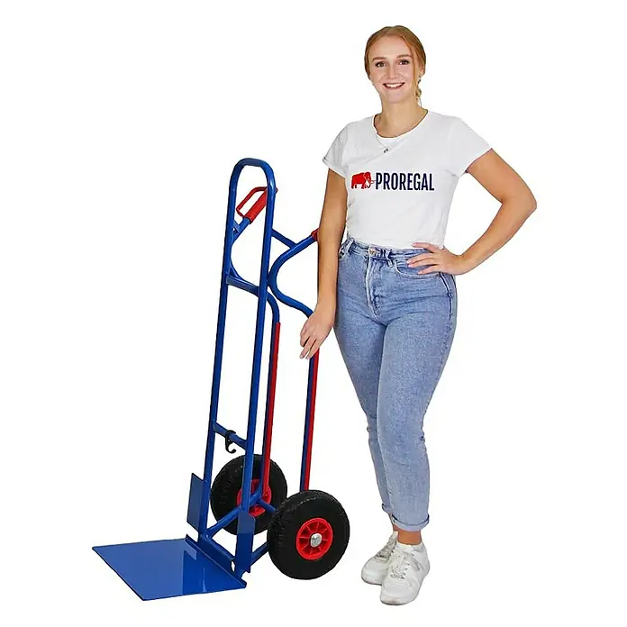 Proregal Sackkarre RAGNAR mit klappbarer XXL Schaufel & PU-Bereifung - Stahl, Traglast: 250 kg - Blauer und roter Sackkarren mit stabilen schwarzen Rädern und roten Naben, daneben eine Person zur Größenorientierung.