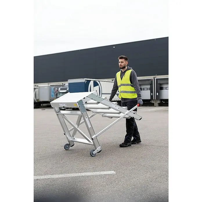 Proregal Treppenpodest Arbeitspodest fahrbar - Anzahl Tritte: 2 Stk., Arbeitshöhe: 2.400 mm, Belastbarkeit: 200 kg, Aluminium - Mann schiebt eine klappbare Aluminium-Arbeitsplattform mit weißen Flächen und Rollen.