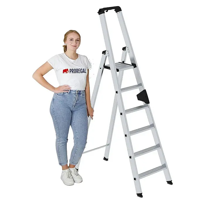 Proregal Stehleiter einseitig begehbar - Anzahl Tritte: 6 Stk., Arbeitshöhe: 3.400 mm, Belastbarkeit: 150 kg, Aluminium - Silberne Aluminium-Klappleiter mit mehreren Stufen und einer oberen Plattform, neben einer Frau zur Veranschaulichung der Größe.