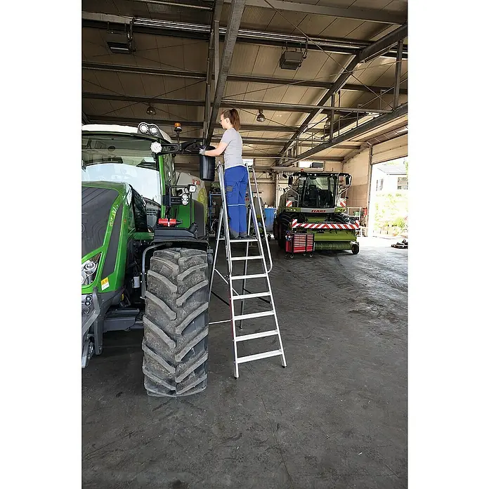 Proregal Stehleiter mit 5 Stufen - Anzahl Tritte: 5 Stk., Arbeitshöhe: 3.150 mm, Belastbarkeit: 150 kg, Aluminium - Hohe silberne Aluminium-Klappleiter, die einer Person das sichere Reinigen eines großen Traktors ermöglicht.
