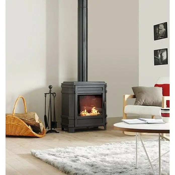 Invicta Estufa de leña Vosges - 8 kW, Volumen de calefacción: 240 m³, Antracita - Esta imagen muestra una estufa de leña, que aporta calidez y estilo a una sala de estar acogedora. Hay una cesta de madera y un juego de herramientas para chimenea.
