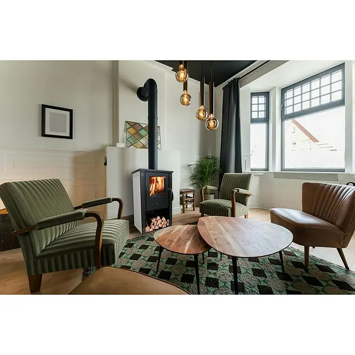 Invicta Estufa de leña Thalia Pella S - 5,4 kW, Volumen de calefacción: 210 m³, Antracita - Acogedora sala de estar con una chimenea moderna, rodeada de elegantes sillones y mesas de centro, creando un ambiente acogedor.