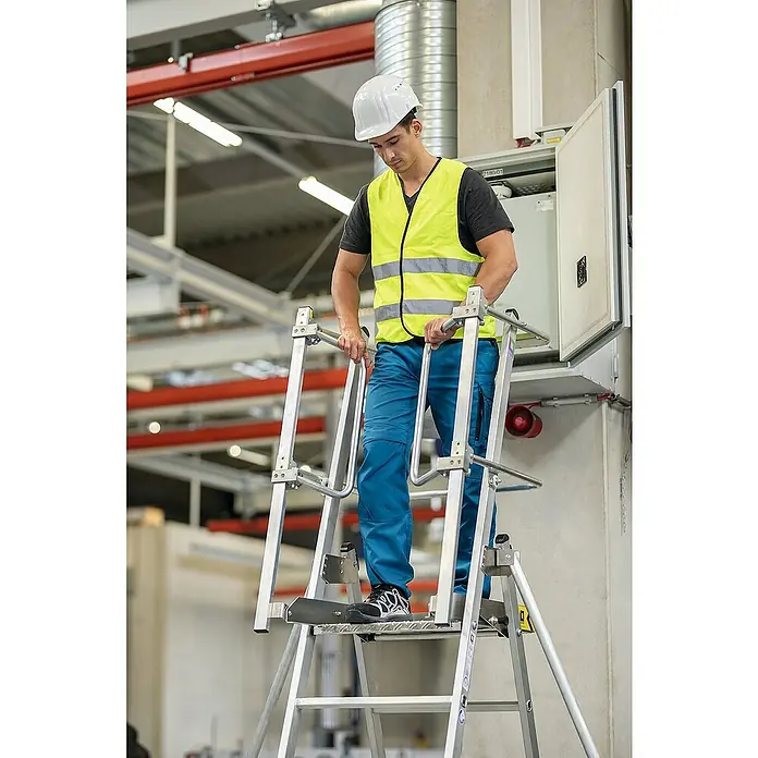 Proregal Stehleiter Plattformleiter Flexstep - Anzahl Tritte: 6 Stk., Arbeitshöhe: 3.550 mm, Belastbarkeit: 150 kg, Aluminium - Arbeiter auf einer silbernen Sicherheits-Plattformleiter in Industrieumgebung, erreicht Schaltschrank.