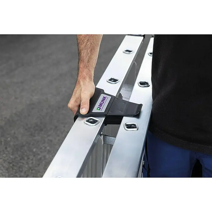Proregal Doppel-Stehleiter beidseitig begehbar - Anzahl Tritte: 12 Stk., Arbeitshöhe: 2.900 mm, Belastbarkeit: 150 kg, Aluminium - Schwarzes MUNK-Leiterzubehör an einer Aluminiumleiter, von einer Hand gehalten.
