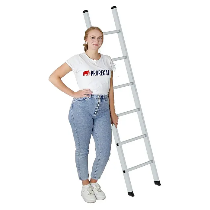 Proregal Anlegeleiter mit 6 Sprossen - Anzahl Tritte: 6 Stk., Arbeitshöhe: 3.000 mm, Belastbarkeit: 150 kg, Aluminium - Eine Frau in weißem 'PROREGAL'-T-Shirt und Jeans steht neben einer hohen, silbernen Aluminiumleiter.