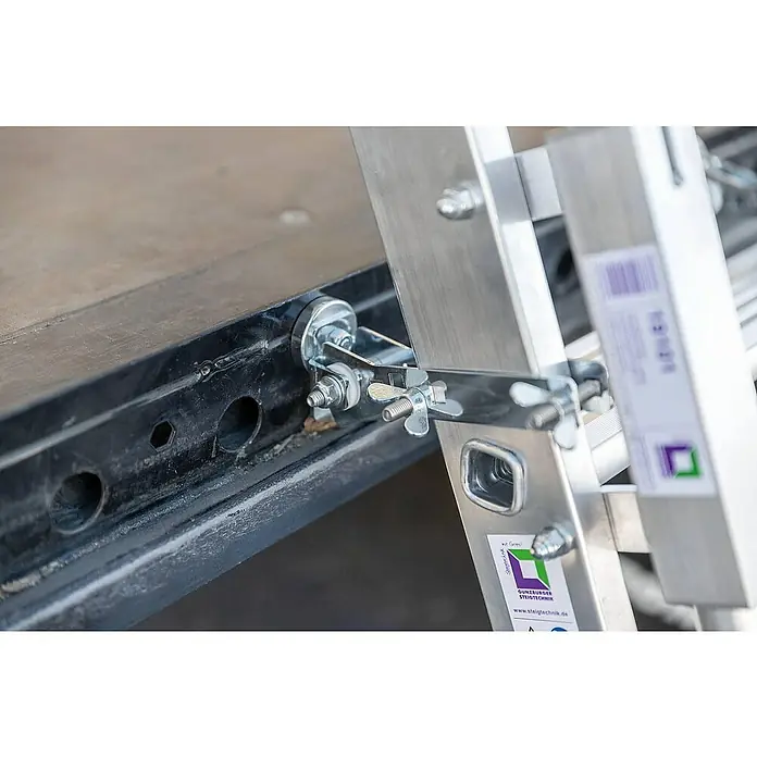 Proregal Anlegeleiter LKW-Leiter mit 5 Stufen - Anzahl Tritte: 5 Stk., Arbeitshöhe: 3.150 mm, Belastbarkeit: 150 kg, Aluminium - Verzinkte Metallklammer mit Flügelmuttern sichert eine Aluminiumleiter an einer dunklen Kante.