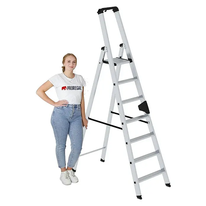 Proregal Stehleiter einseitig begehbar - Anzahl Tritte: 7 Stk., Arbeitshöhe: 3.700 mm, Belastbarkeit: 150 kg, Aluminium - Silberne Aluminium-Klappleiter mit schwarzen Akzenten, daneben eine Person zur Größenangabe.