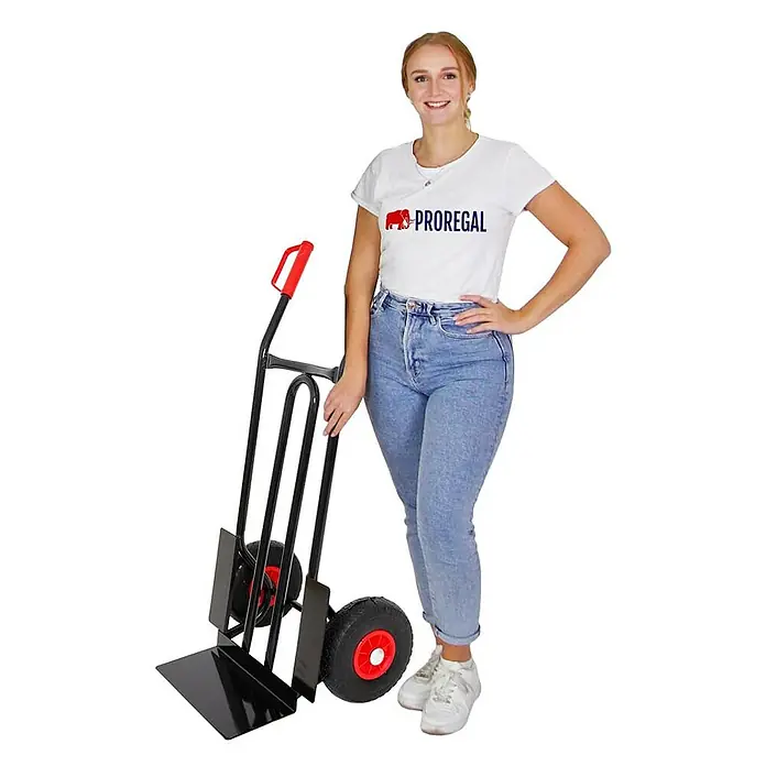 Proregal Sackkarre RHINO mit XL Schaufel, 250 kg Traglast & PU-Bereifung - Stahl, Traglast: 250 kg - Schwarze Sackkarre mit roten Rädern, von einer Frau gehalten, bereit zum Transport.