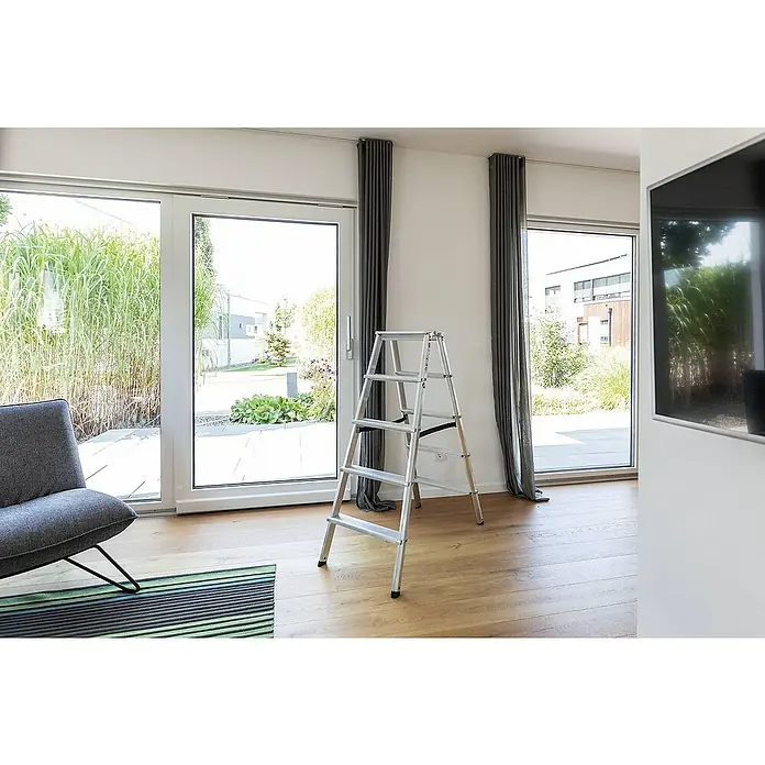 Proregal Doppel-Stehleiter beidseitig begehbar - Anzahl Tritte: 12 Stk., Arbeitshöhe: 2.950 mm, Belastbarkeit: 150 kg, Aluminium - Silberne Aluminium-Klappleiter auf Holzfußboden in hellem Raum.