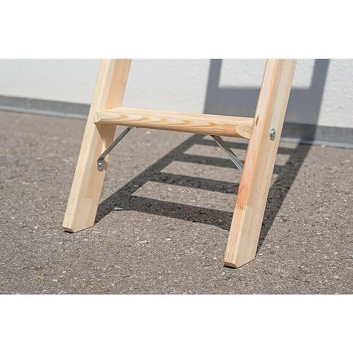 Proregal Anlegeleiter mit 8 Stufen - Anzahl Tritte: 8 Stk., Arbeitshöhe: 3.170 mm, Belastbarkeit: 150 kg, Holz - Nahaufnahme des unteren Teils einer hellen Holz-Klappleiter mit silbernen Metallstreben, auf Asphalt stehend.