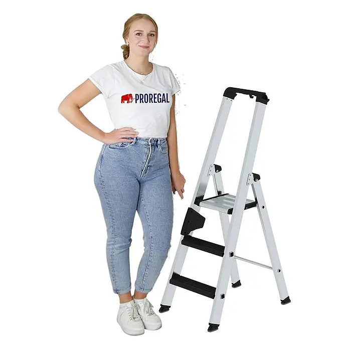 Proregal Stehleiter einseitig begehbar - Anzahl Tritte: 3 Stk., Arbeitshöhe: 2.700 mm, Belastbarkeit: 150 kg, Aluminium - Silberne Aluminium-Trittleiter mit schwarzen Stufen, eine Frau steht daneben zur Größenangabe.