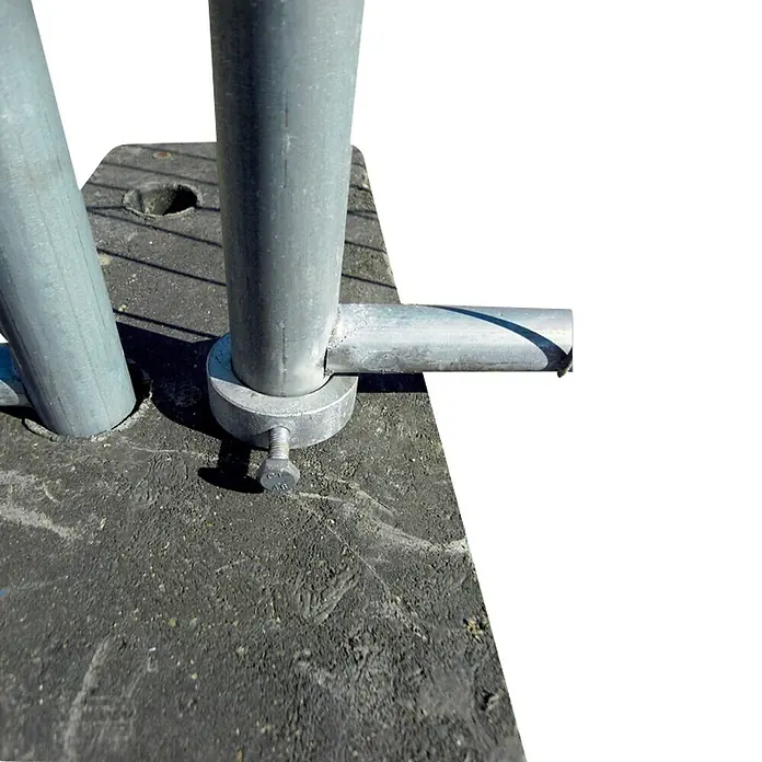Schake Bauzaun Drehtor Laufring - Stahl, Verzinkt - Nahaufnahme einer silberfarbenen Metallstange, die mit einem Bolzen an einer Betonoberfläche befestigt ist. Die Metallstruktur zeigt Details wie die Schraube.