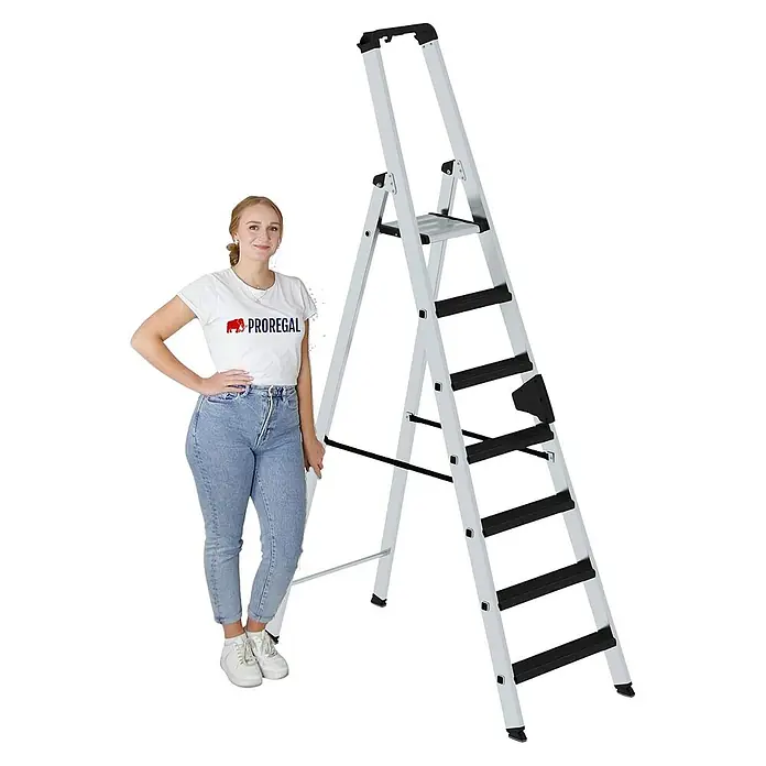 Proregal Stehleiter einseitig begehbar - Anzahl Tritte: 7 Stk., Arbeitshöhe: 3.650 mm, Belastbarkeit: 150 kg, Aluminium - Silberne Aluminium-Klappleiter mit schwarzen Anti-Rutsch-Stufen. Eine Frau steht daneben und veranschaulicht Größe und Höhe.