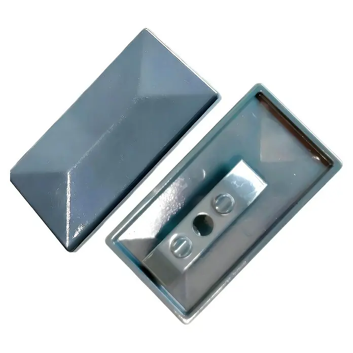 FA-Bausysteme Pfostenkappe mit Überstand - Anthrazit, Aluminium, Passend für: Pfosten Doppelstabmattenzaun - Ein Paar graue Zaunpfostenkappen liegen auf einem schwarzen Untergrund. Die Kappen schützen Zaunpfosten vor Witterungseinflüssen.