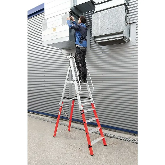 Proregal Stehleiter steckbar - Anzahl Tritte: 3 Stk., Arbeitshöhe: 2.700 mm, Belastbarkeit: 150 kg, Aluminium - Mann auf einer rot-silbernen Stehleiter, der an einer Lüftungsanlage an einer Wellblechwand arbeitet.