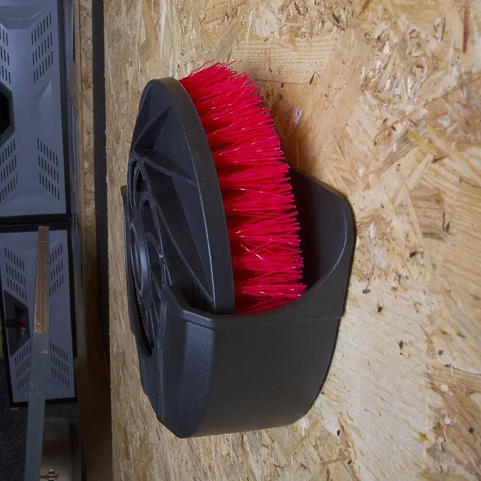 Batavia Maxxpack Wandhalterung - Kunststoff, Passend für: Batavia Akku-Reinigungsbürste Twin Brush - Eine Schuhputzbürste mit roten Borsten und schwarzem Gehäuse an einer Holzwand. Praktisches Reinigungszubehör.