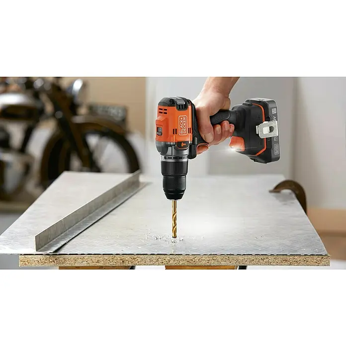 Black+Decker 18V PowerConnect Taladro atornillador percutor de batería BLD683XN-XJ - 18 V, Sin batería, 50 Nm, Número máx. de impactos: 28.800 /min - Un taladro inalámbrico Black+Decker perfora una lámina de metal, destacando la broca, la batería y la empuñadura.