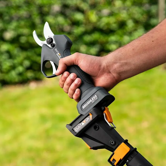Batavia Akku-Astschere 18V - 18 V, Ohne Akku, Max. Aststärke: 30 mm - Nahaufnahme einer batteriebetriebenen Batavia Astschere, die von einer Hand gehalten wird, vor einem unscharfen, grünen Hintergrund.