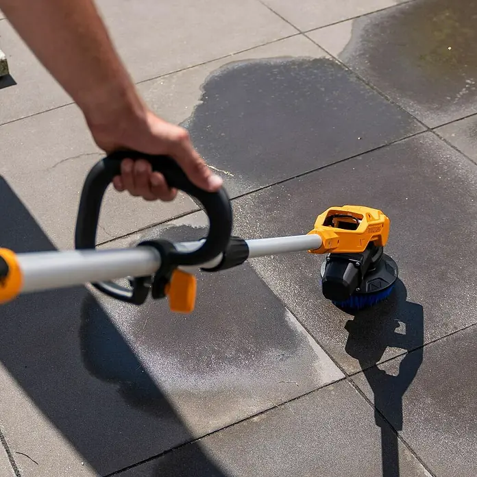 Batavia Akku-Reinigungsbürste Twin Brush Compact - 12 V, Ohne Akku - Der Worx Akku-Bürstenreiniger im Einsatz, um Außenbereiche wie Terrassen und Einfahrten effektiv von Schmutz zu befreien.