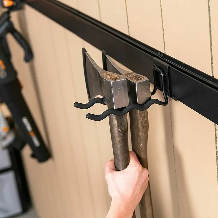 Batavia Maxxclick Doppel-Wandhaken Wave - Passend für: Batavia Maxxclick Wellenhaken - Nahaufnahme von zwei Äxten, die an einem schwarzen Haken an einer Wand hängen. Aufbewahrung von Werkzeugen für mehr Ordnung im Haus.