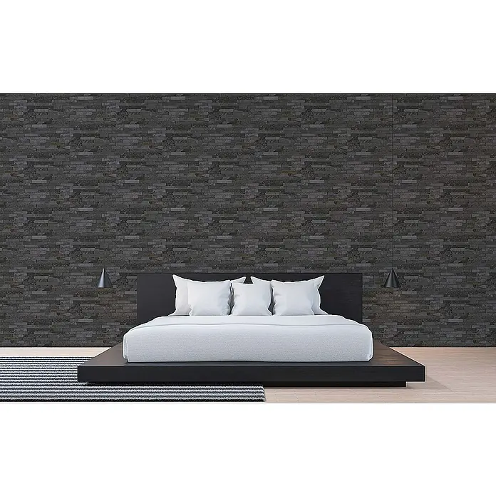 Tadessi Vliestapete M1-No.112 - Schwarz, Steinoptik, 10,05 x 0,53 m - Modernes schwarzes Plattformbett mit weißer Bettwäsche und Kissen, in einem Schlafzimmer mit dunkler Ziegelwand.