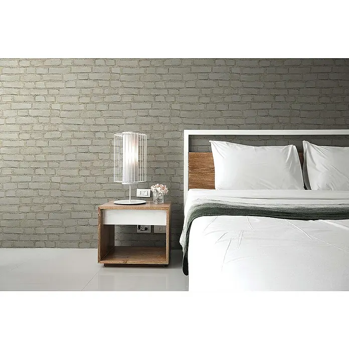 Tadessi Vliestapete M1-No.396 - Grau, Steinoptik, 10,05 x 0,53 m - Moderner Nachttisch aus Holz mit weißer Schublade, darauf eine weiße Lampe und kleine Blumen, neben einem Bett.