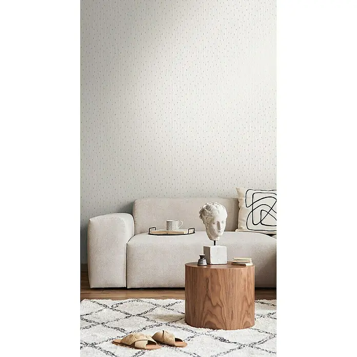 Tadessi Vliestapete M1-No.4031 - Creme, Streifen, 10,05 x 0,53 m - Dezente helle Tapete mit feinem vertikalem Strichmuster, in einem modernen Wohnzimmer hinter einem Sofa.