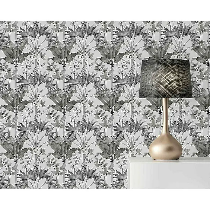 Tadessi Vliestapete M1-No.4434 - Schwarz, Floral, 10,05 x 0,53 m - Monochromatische botanische Tapete mit großen Blättern und vertikalen Streifen, hinter einer Tischlampe.