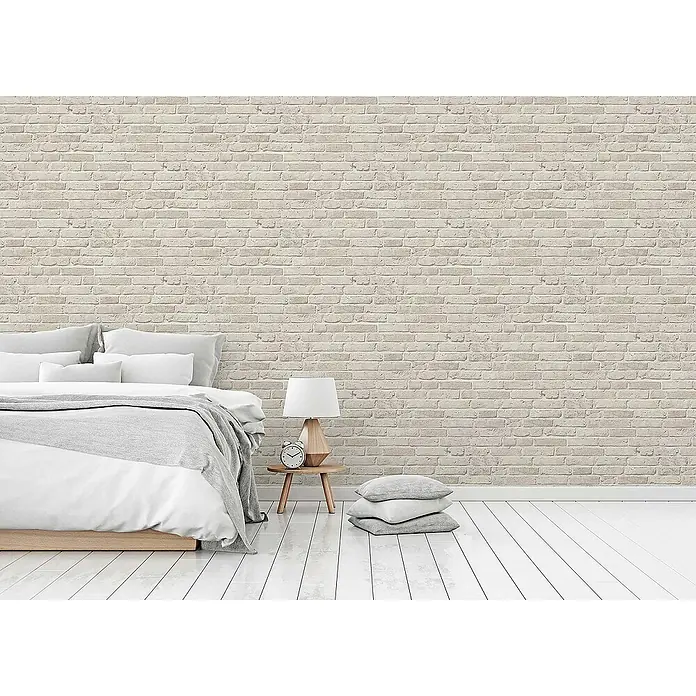 Tadessi Vliestapete M1-No.109 - Grau, Steinoptik, 10,05 x 0,53 m - Hellfarbige Ziegelwand in einem Schlafzimmer, als Hintergrund für Bett, Nachttisch und Kissen.