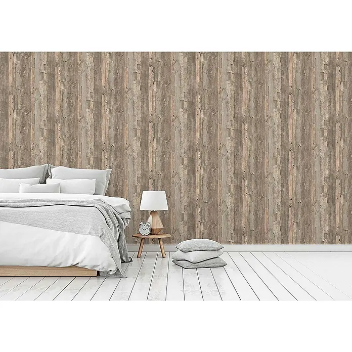 Tadessi Vliestapete M1-No.904 - Beige, Holzoptik, 10,05 x 0,53 m - Rustikale Holzpaneel-Tapete bedeckt eine Schlafzimmerwand, zeigt Textur und Design neben Bett und Lampe.