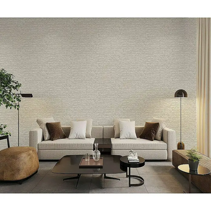 Tadessi Vliestapete M1-No.4191 - Braun, Steinoptik, 10,05 x 0,53 m - Texturierte beigefarbene Tapete schmückt eine Wohnzimmerwand über einem modernen Sofa und schafft eine warme Atmosphäre.