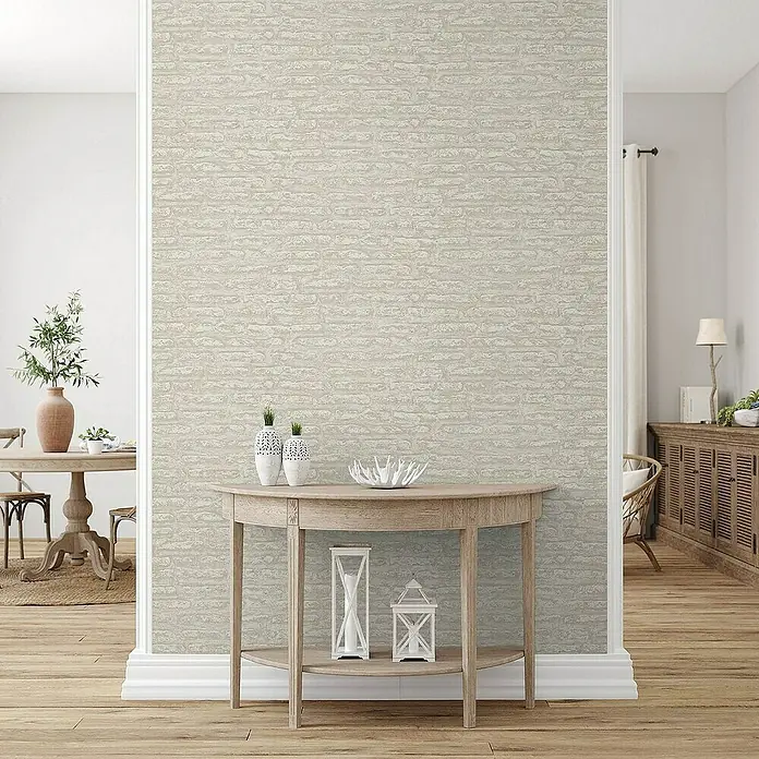 Tadessi Vliestapete M1-No.4191 - Braun, Steinoptik, 10,05 x 0,53 m - Helle beigefarbene Tapete mit Ziegelmuster an einer Wand in einem einladenden Interieur, umrahmt von Türen und Möbeln.