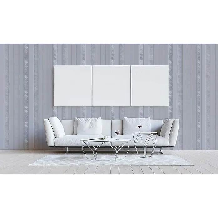 Tadessi Vliestapete M1-No.879 - Silber, Streifen, 10,05 x 0,7 m - Ein modernes Wohnzimmer mit weißem Sofa, zwei weißen geometrischen Couchtischen und drei leeren weißen Leinwänden an einer gemusterten Wand.