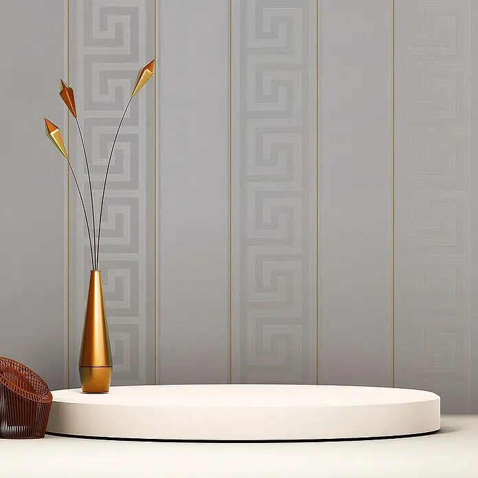 Tadessi Vliestapete M1-No.879 - Silber, Streifen, 10,05 x 0,7 m - Weißes, rundes Präsentationspodest auf hellem Boden vor grau-gold gestreifter Tapete, mit goldener Vase und Korbstuhl daneben.