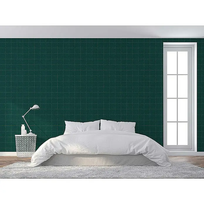 Tadessi Vliestapete M1-No.3160 - Grün, Fliesenoptik, 10,05 x 0,53 m - Dunkelgrüne Tapete mit subtilem goldenem Gittermuster, an einer Schlafzimmerwand hinter einem Bett.