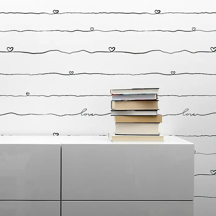 Tadessi Vliestapete M1-No.1549 - Schwarz, Sonstiges, 10,05 x 0,53 m - Weißer moderner Schrank mit Bücherstapel darauf, vor schwarzem Linien- und Herzmuster.
