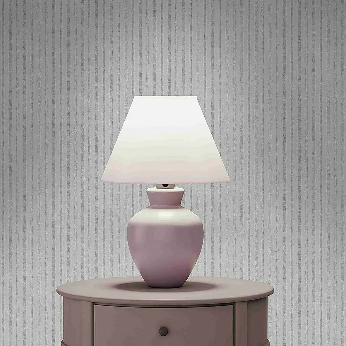 Tadessi Vliestapete M1-No.4309 - Creme, Streifen, 10,05 x 0,53 m - Rosa Keramiktischlampe mit weißem Stoffschirm auf einem passenden runden Nachttisch mit kleiner Schublade.