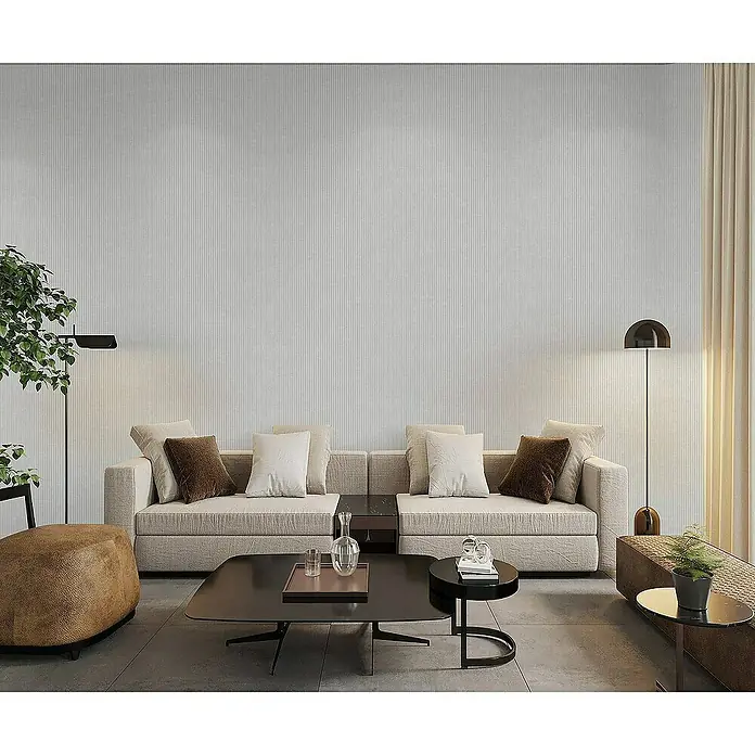 Tadessi Vliestapete M1-No.4309 - Creme, Streifen, 10,05 x 0,53 m - Hellgraue, texturierte Tapete mit feinen vertikalen Streifen an einer Wohnzimmerwand hinter einem modernen Sofa.