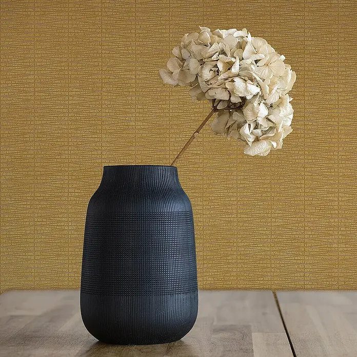 Tadessi Vliestapete M1-No.1708 - Gelb, Sonstiges, 10,05 x 0,53 m - Schwarze strukturierte Vase mit Trockenblume, auf Holztisch in einem Raum.
