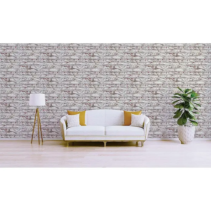 Tadessi Vliestapete M1-No.181 - Weiß, Steinoptik, 10,05 x 0,53 m - Eine weiß getünchte Backsteinwand in einem modernen Wohnzimmer mit weißem Sofa, Stehlampe und Grünpflanze.