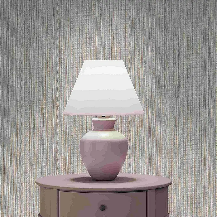Tadessi Vliestapete M1-No.4175 - Rosa, Streifen, 10,05 x 0,53 m - Hellrosafarbene Tischlampe mit weißem Schirm auf passendem runden Nachttisch vor gemusterter Wand.
