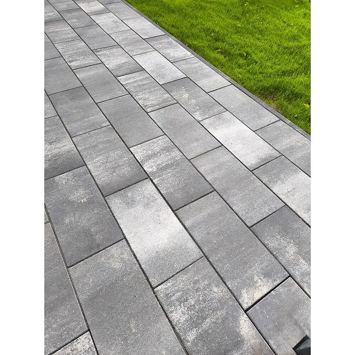 EHL EIBA Terrassenplatte - 60 x 26,6 x 5 cm, Grau-Anthrazit, Beton - Graue Pflastersteine bilden einen modernen Gehweg neben einem grünen Rasen. Die Steine sind rechteckig und in einem versetzten Muster verlegt.